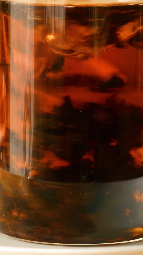 A teaspoon stirs tea in a glass. Vertical video. Stock Footage 325705474