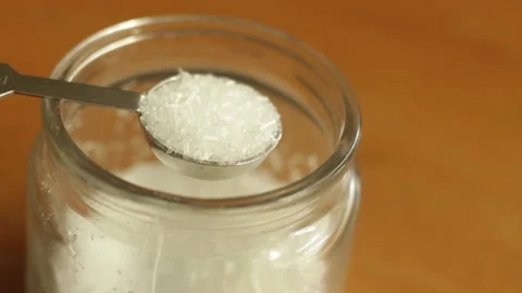 A teaspoon of white refined MSG monosodium glutamate powder is being scooped Stock Footage 222692224