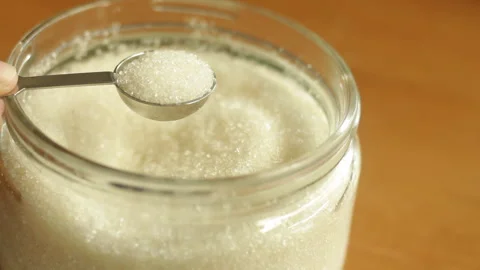 A teaspoon of white refined sugar cane is being scooped with stainless steel Stock Footage 222688921