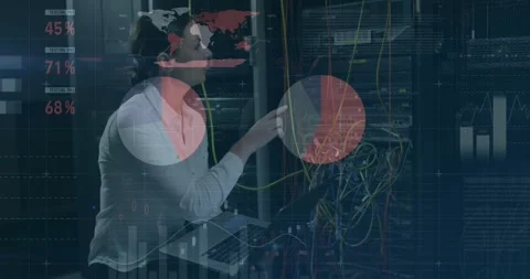 Tech adjusting cables and typing on laptop at IT rack updating overlay graphs Stock Footage 330444241