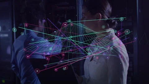 Tech adjusting rack while woman tapping tablet as network surge causing nodes Stock Footage 332747043