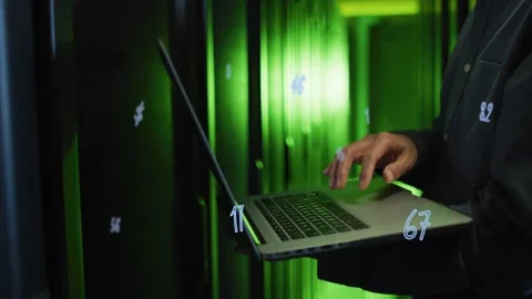 Tech analyzing data hovering, typing laptop in green racks, causing floating Stock Footage 334038233