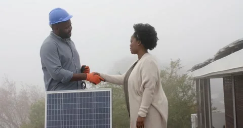 Tech in blue hard hat orange gloves offering cable client taking it completing Stock Footage 342363120