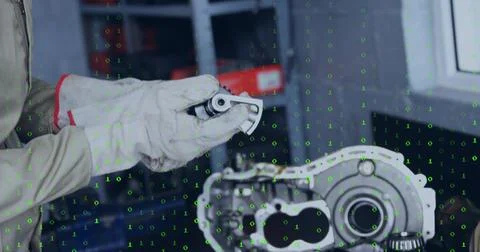 Tech checking bearing in shop with light jacket red-trim white gloves, gearbox Stock Photos