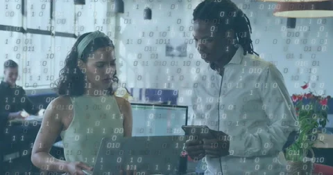 Tech colleagues standing and looking at laptop and phone in office, binary Video stock 330160306
