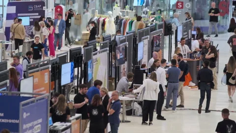 Tech conference with diverse attendees networking and exhibiting innovations 스톡 동영상 279948020