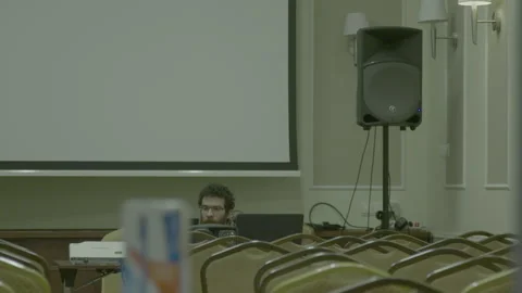 Tech crew working on laptops in an auditorium Stock Footage 341863825