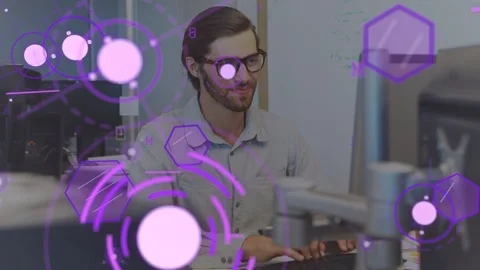Tech dev working typing causing purple overlays drifting before him while Stock Footage 333648903
