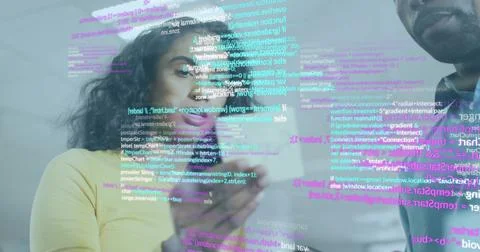 Tech developers examining transparent code overlay in office with smartphone and Stock Photos