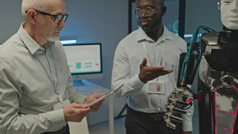 Tech Developers Operating Humanoid Robot on Tablet PC Stock Footage 248693656