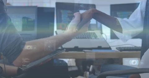 Tech devs reaching across desk shaking hands over code screens overlay covering Stock Footage 330356066