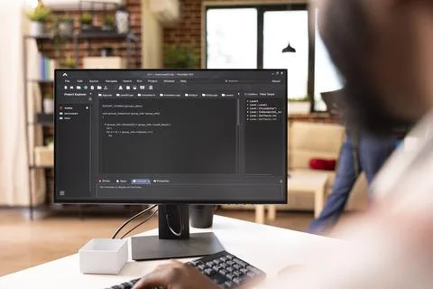 Tech freelancer writes code on computer in modern home Stock Photos