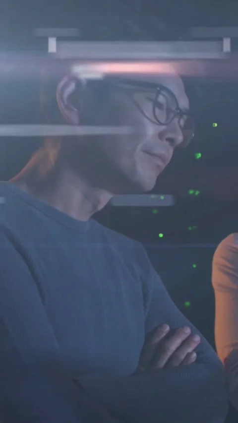 Tech with glasses standing with crossed arms checking servers as pink bars Stock Footage 334604672