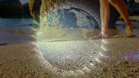 Tech globe overlay fading over beach guiding man wading for leisure with binary Stock Footage 311083262
