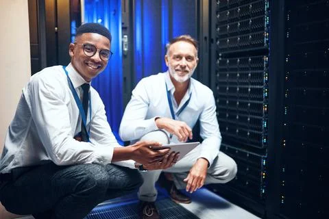 The tech gurus are on the case. Portrait of two technicians using a digital Stock Photos