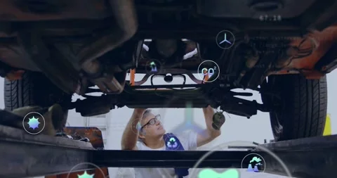 Tech inspecting auto underside as lift rising probing mounts for diagnosis while Stock Footage 334036564