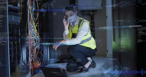 Tech kneeling at rack, tapping PC while phoning, showing network code overlay Video stock 330330993