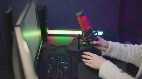 Tech Lady Adjusting Desktop Microphone and Cable near RGB Monitor Setup Stock Footage 307458712