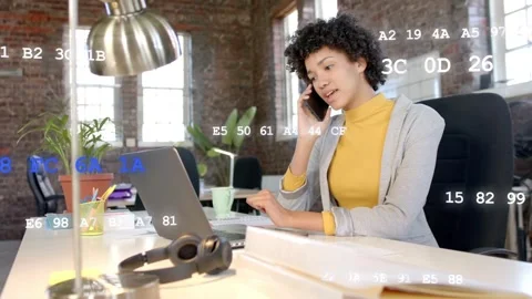 Tech pro answering phone, typing laptop in loft, code overlay signaling incoming Stock Footage 333648643