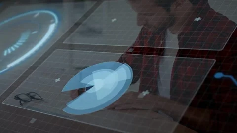 Tech pro leaning over clear surface, tapping stylus and rotating blue hologram Stock Footage 333193080