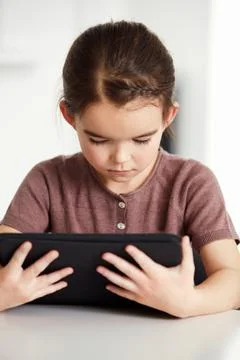 Tech savvy developer in the making. an adorable little girl reading a digital Stock Photos