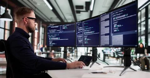 Tech-savvy Programmer Creates Innovative Code On Office Desktop Computer Scre Stock-Fotos