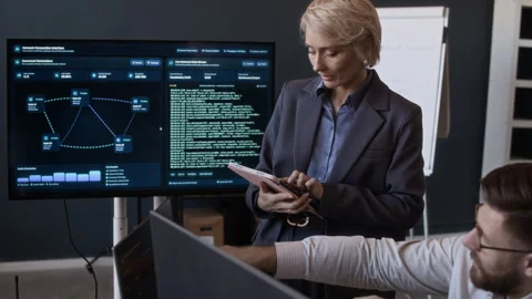 Tech Specialists Analyzing Network Data in Office Stock Footage 334934307