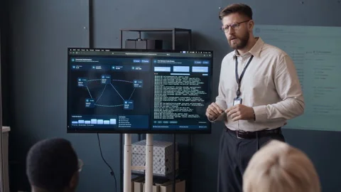 Tech Specialists Listening to Network Engineer during Presentation in Office 動画素材 334932042