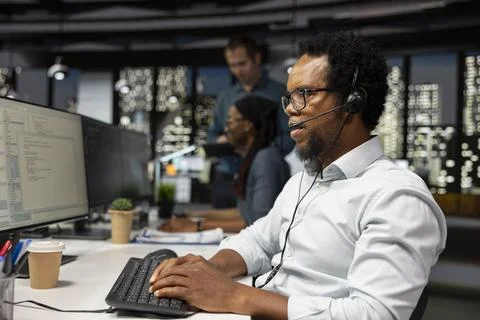 Tech support expert resolving technical problems for users during remote call Stock-Fotos