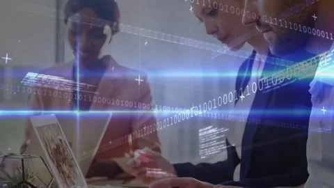 Tech team leaning over laptop and tablet, analyzing data while binary code Stock Footage 331333542
