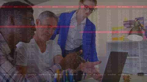Tech team leaning over laptop, peer tapping pad, building code overlay covering Stock Footage 333445689