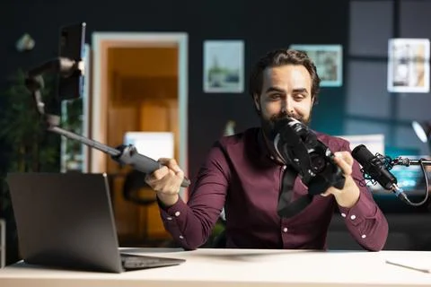 Tech vlogger reviewing VR glasses in apartment studio, presenting specifications Stock Photos