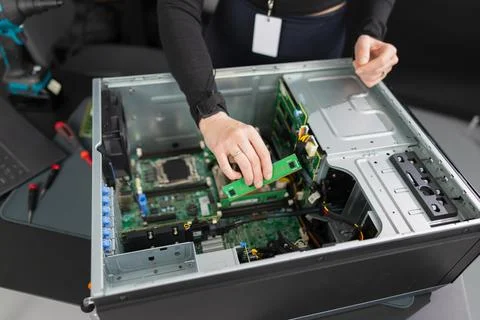 Tech worker in a server chassis upgrading RAM and components inside a desktop Stock Photos