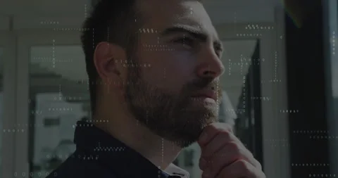 Tech worker standing by window in office responding to floating binary code, Stock Footage 312100243