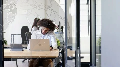 Tech worker typing on laptop, causing globe overlaying man for global view and Stock Footage 334322127