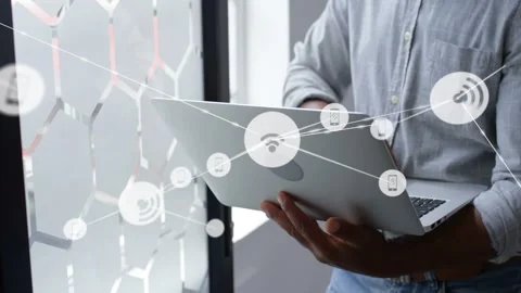 Tech worker typing on laptop near patterned glass, creating animated IoT nodes Stock Footage 333902398
