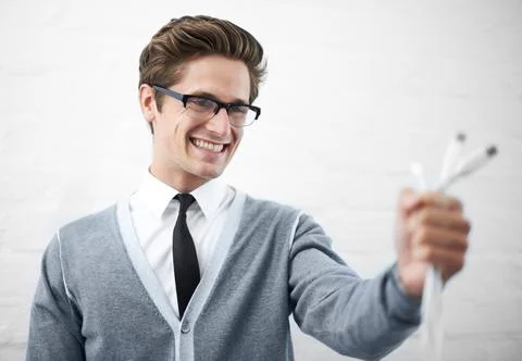 Techie alert. A young nerdy guy holding usb cables toward the camera. Stock Photos