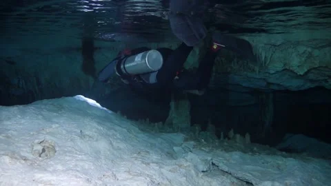 Technical diver exploring a submerged cave with stalactites and following a Stock-Footage 332001192