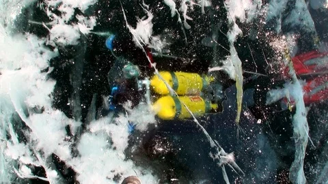 Technical diver under frozen ice hole underwater of lake Baikal. Stock Footage 100787675