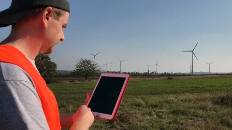 Technical engineer touching tablet on field at wind turbines Stock Footage 98152457