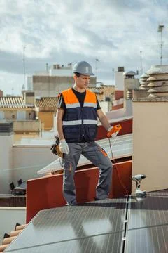 Technical engineer worker installing solar panels on a house roof of city Foto stock
