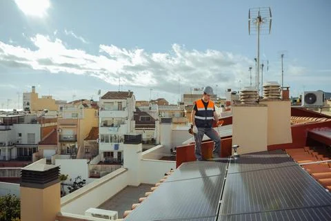 Technical engineer worker installing solar panels on a house roof of city Stock Photos
