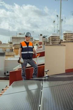 Technical engineer worker installing solar panels on a house roof of city Stock Photos