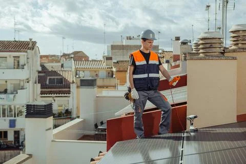 Technical engineer worker installing solar panels on a house roof of city Stock Photos