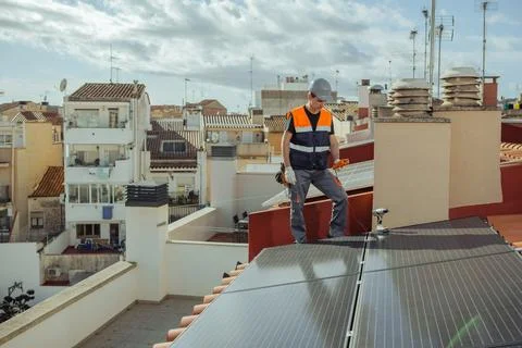 Technical engineer worker installing solar panels on a house roof of city Stock Photos
