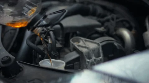 Technical fluid is being carefully poured into the car engine compartments d Stock Footage 331363002