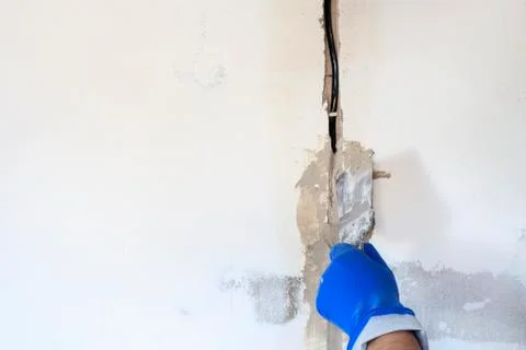 Technical hole in it is an electrical wire. the wall is white. Master with a  Stock Photos