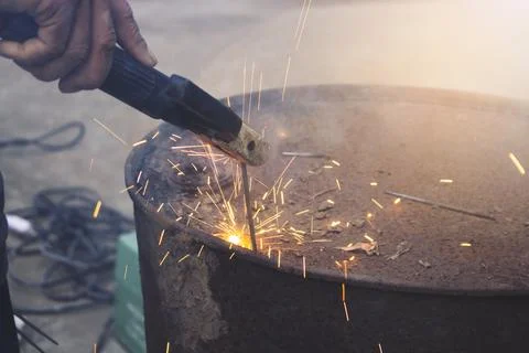 The technical Industry worker welding iron pieces tank at work with a spark.. Stock Photos