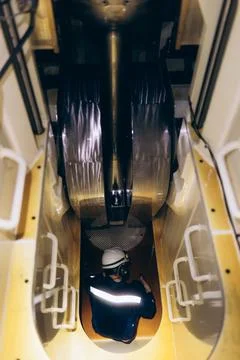 Technical maintenance: Ship mechanic working inside a giant diesel engine. Stock Photos