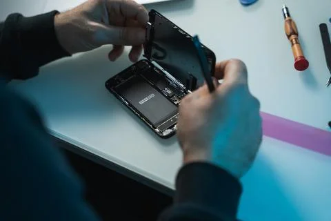 Technical man closing the smartphone after installing a new battery Stock Photos
